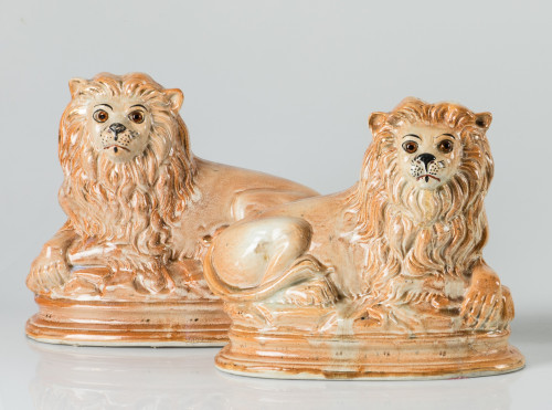 "Pareja de leones", figuras de loza esmaltada en color ocre