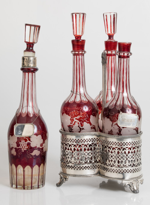 Four glass and wine-colored glass decanter bottles, possibl