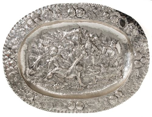 Decorative tray in raised silver, depicting a battle scene